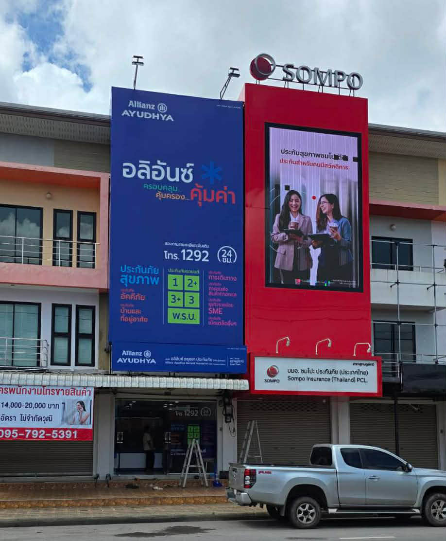 อาคารสำนักงานประกันภัยอลิอันซ์อยุธยาและซมโปะประกันภัยประเทศไทย พร้อมป้ายโฆษณาขนาดใหญ่และรถกระบะจอดด้านหน้า