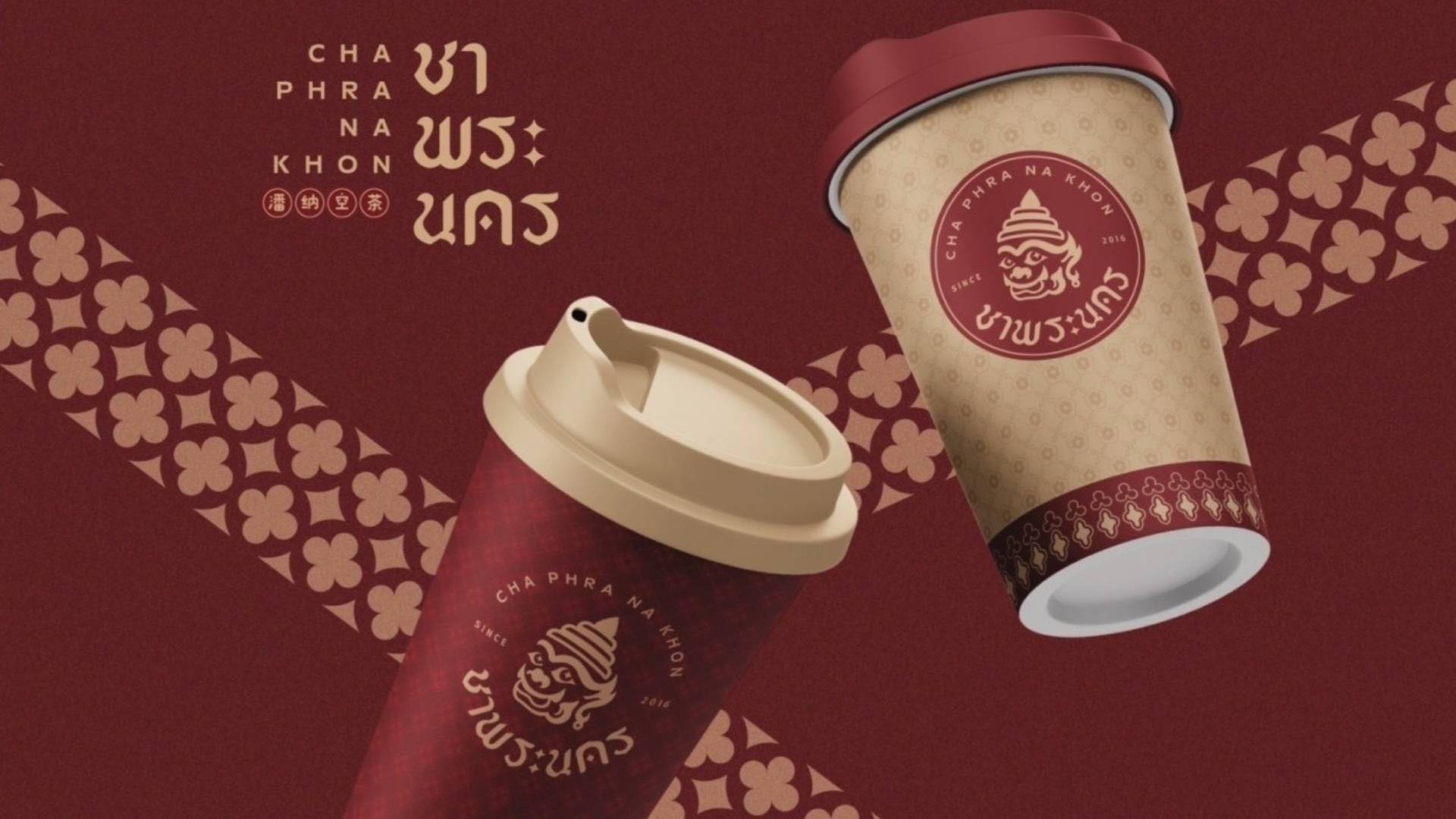 แก้วกาแฟแบรนด์ชาพระนคร ดีไซน์สีแดงเข้มและครีมพร้อมลายไทยและโลโก้หัวยักษ์