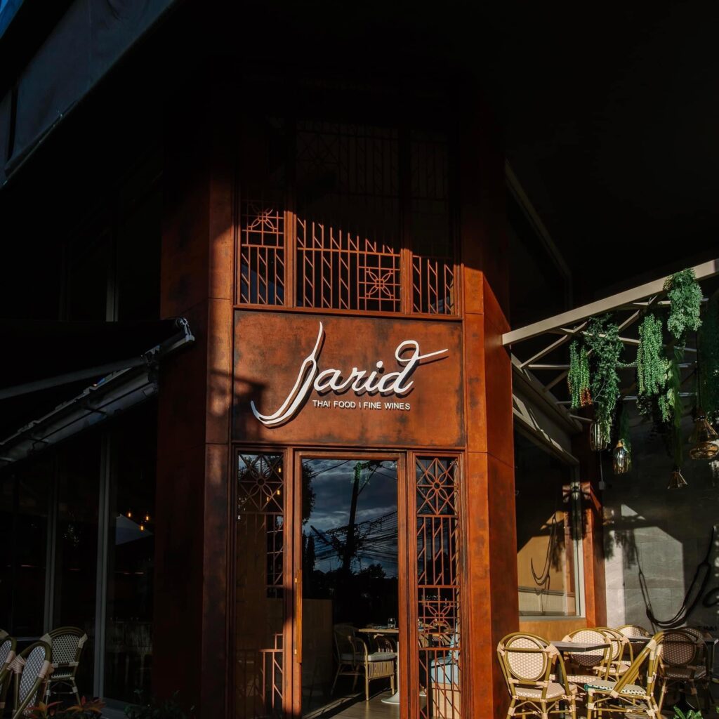 ทางเข้าร้านอาหารไทย Jarid Thai Food Fine Wines ตกแต่งด้วยโทนสีส้มอิฐสไตล์วินเทจพร้อมลวดลายกระจกฉลุ