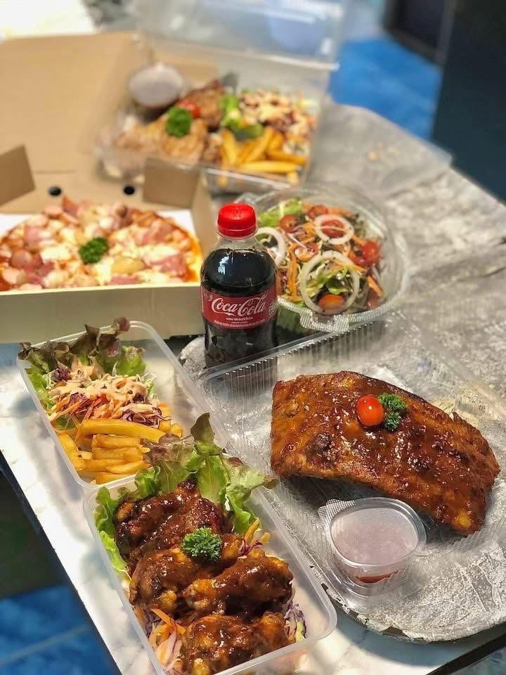 อาหารสั่งกลับบ้านหลากหลายเมนู พิซซ่า ซี่โครงบาร์บีคิว ปีกไก่ทอดซอส สลัด เฟรนช์ฟรายส์ และโค้ก