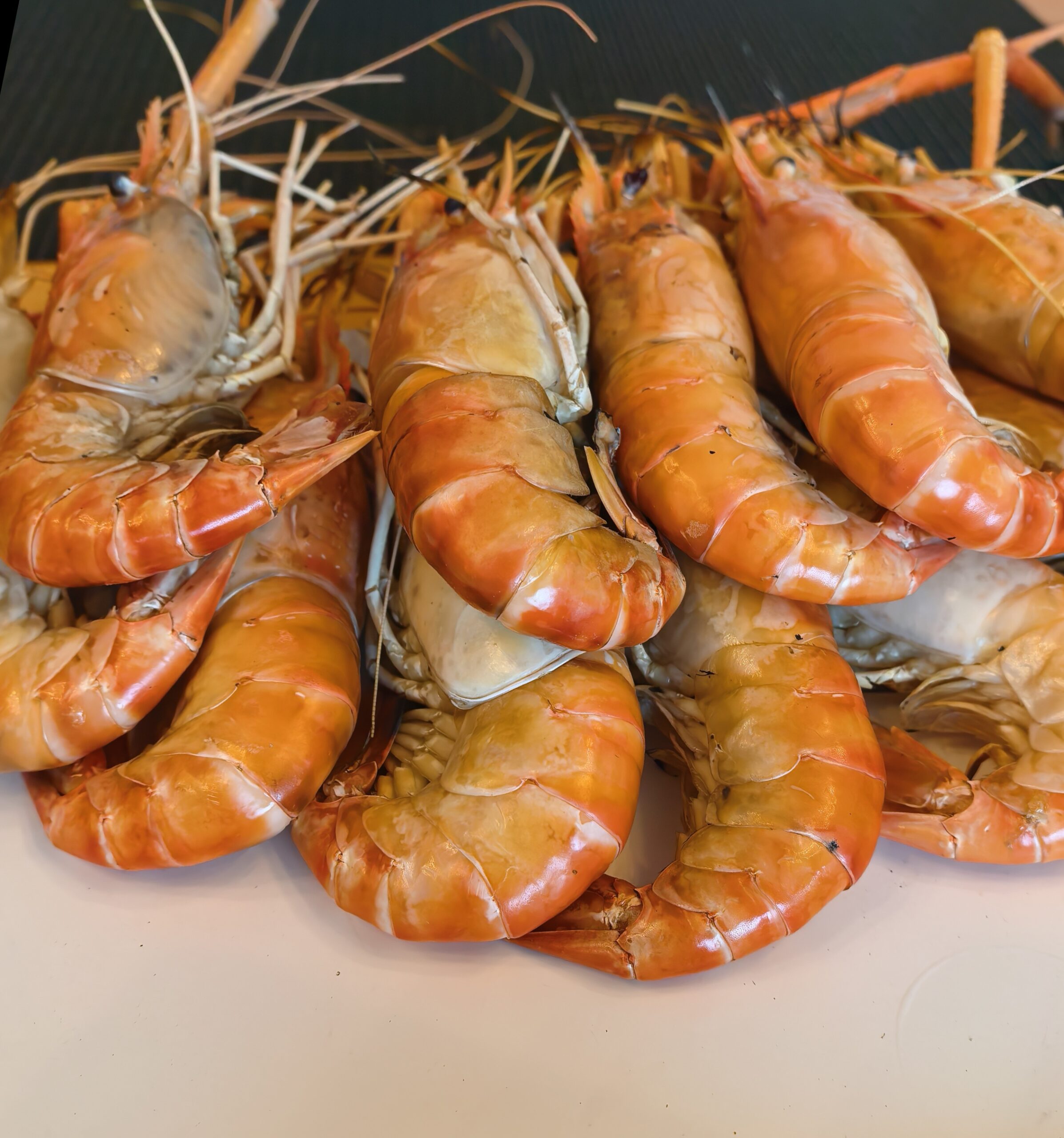 กุ้งแม่น้ำตัวใหญ่ต้มสุกสีส้มสดกองอยู่บนจาน