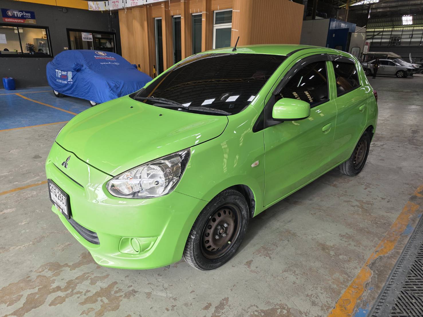 รถยนต์มิตซูบิชิ มิราจ สีเขียวจอดอยู่ในโรงจอดรถ