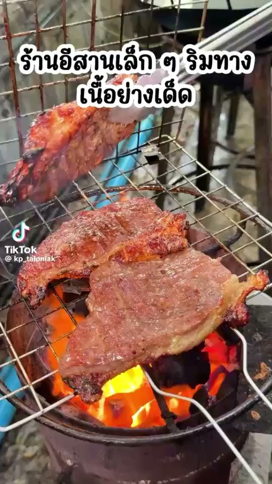 เนื้อย่างบนเตาถ่านร้านอีสานเล็กๆ ริมทาง เนื้อชิ้นใหญ่ย่างบนตะแกรงไฟแดงร้อน