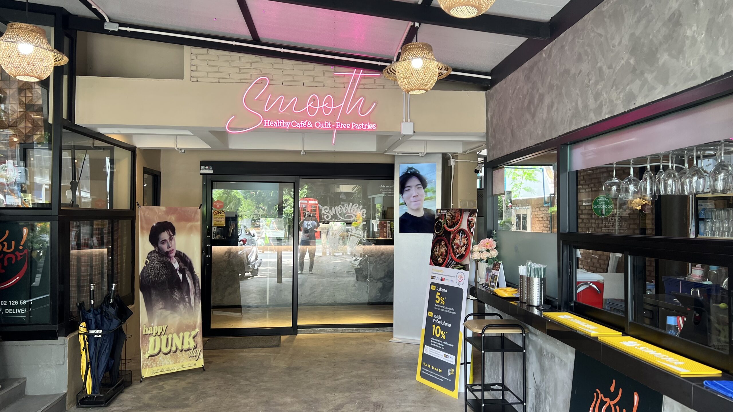 ทางเข้าร้าน Smooth Healthy Cafe & Guilt-Free Pastries พร้อมป้ายไฟนีออนสีชมพูและบาร์เคาน์เตอร์