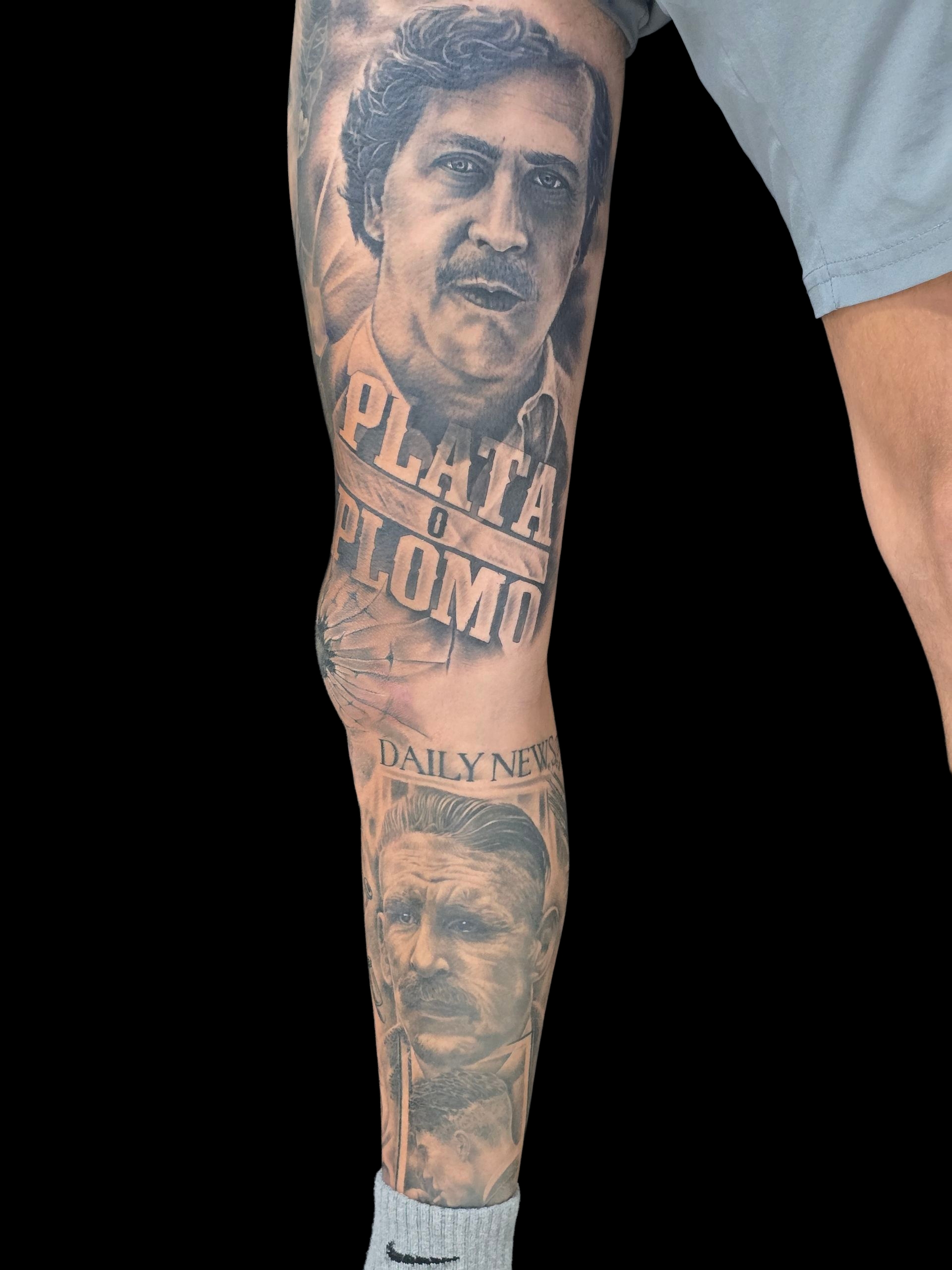 รอยสักเต็มขาสไตล์เรียลลิสติกขาวดำรูปใบหน้าผู้ชายพร้อมข้อความ Plata o Plomo และ Daily News