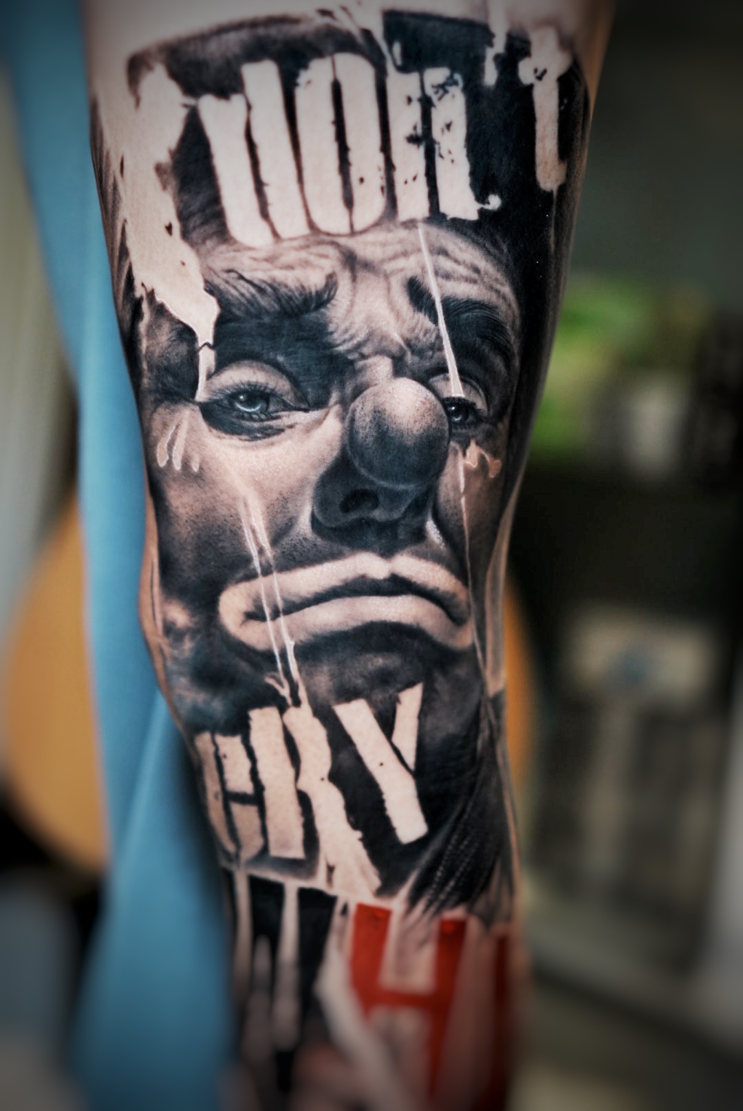 รอยสักรูปหน้าตัวตลกร้องไห้พร้อมข้อความว่า Don't Cry บนแขน