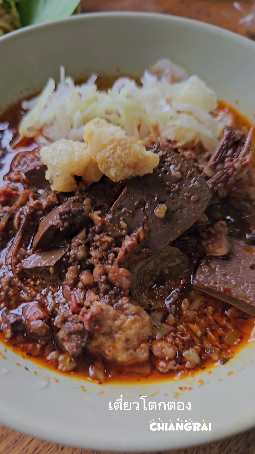 เตี๋ยวโตกตอง เชียงราย ก๋วยเตี๋ยวเรือน้ำตกในชามพร้อมเครื่องในและแคบหมู