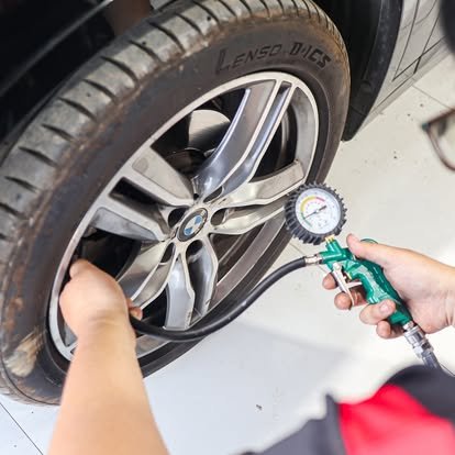 มือกำลังใช้เกจวัดแรงดันลมยางตรวจสอบลมยางรถยนต์ BMW