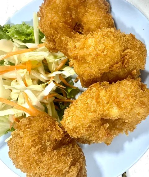 กุ้งทอดเกล็ดขนมปังกรอบเสิร์ฟพร้อมสลัดผักสด บนจานสีขาว