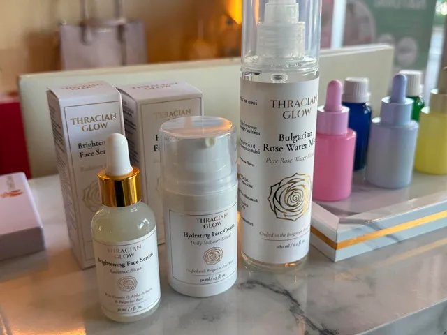 ผลิตภัณฑ์ดูแลผิว Thracian Glow รวมถึงเซรั่มเพิ่มความกระจ่างใส ครีมบำรุงผิวหน้า และสเปรย์น้ำกุหลาบบัลแกเรีย วางเรียงบนเคาน์เตอร์หินอ่อน